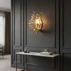 Botanical crystal branch wall sconce in gold with glowing bulb and clear faceted drops