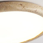 Travertine-look ring detail around a flush ceiling light with warm light glow