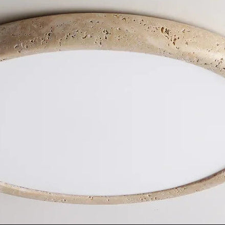 Close-up of travertine-look circular ceiling flush mount light with textured edge