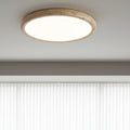 Round flush mount ceiling light with travertine-style ring, emitting soft light upward