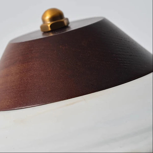 Close-up of dark ceramic lampshade top with small brass knob